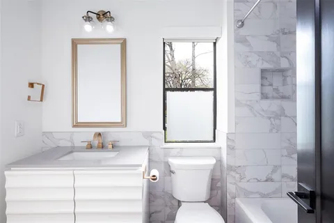 a bathroom with a toilet sink a mirror and a window