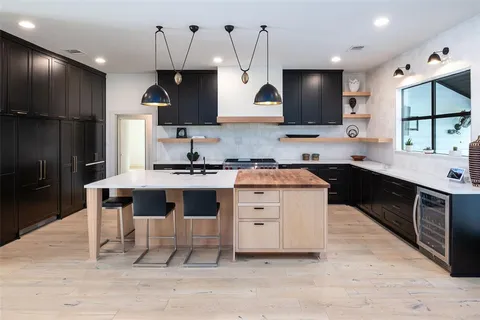 a kitchen with stainless steel appliances kitchen island granite countertop a sink stove and cabinets
