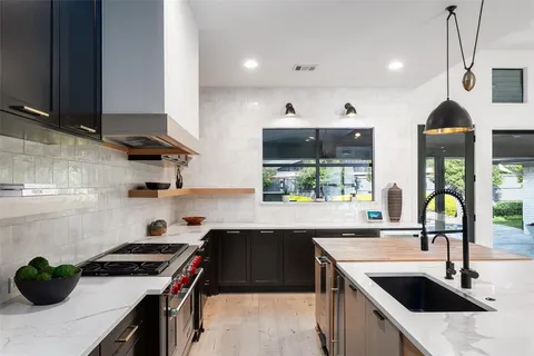 a kitchen with stainless steel appliances a sink stove and cabinets
