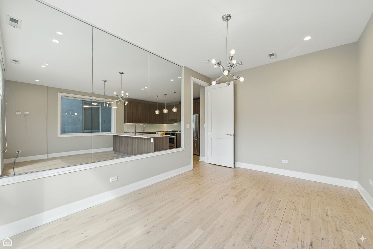 826 West Cullerton Street, Unit 2W Chicago, IL 60608 - Photo 12 of 23 wooden floor in an empty room with a kitchen
