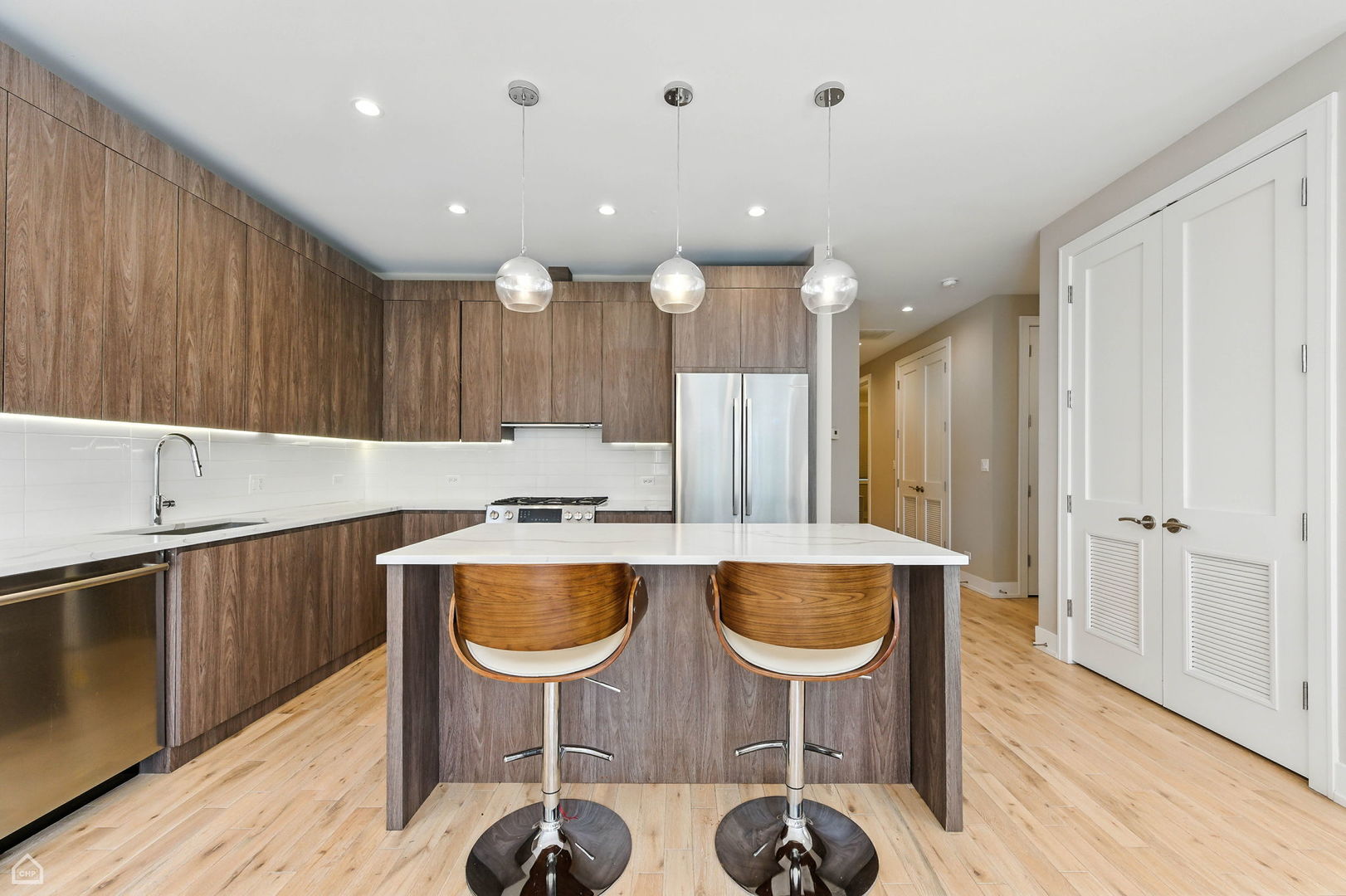 826 West Cullerton Street, Unit 2W Chicago, IL 60608 - Photo 8 of 23 a kitchen with stainless steel appliances granite countertop a table chairs sink and cabinets