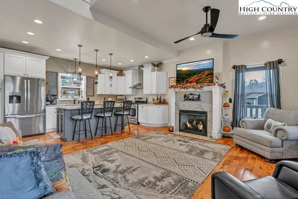 a kitchen with stainless steel appliances granite countertop a sink a stove a refrigerator and wooden floor