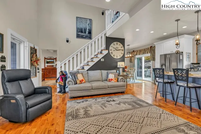 a kitchen with stainless steel appliances granite countertop a refrigerator a stove a sink dishwasher and a fireplace with wooden floor