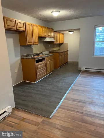 a kitchen with stainless steel appliances granite countertop a sink stove and wooden floor