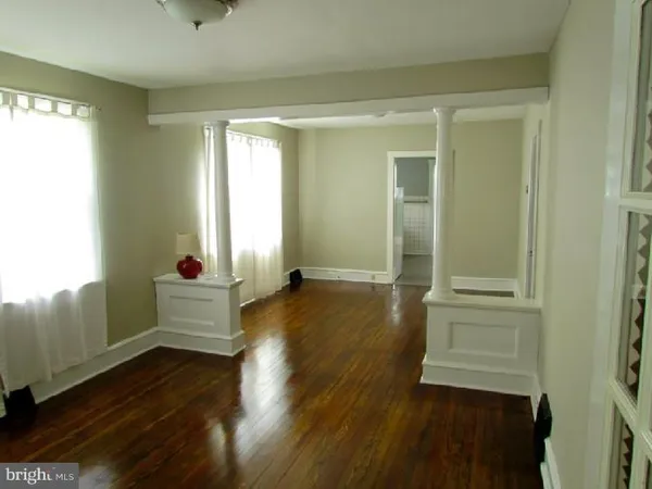 a room with wooden floor and windows