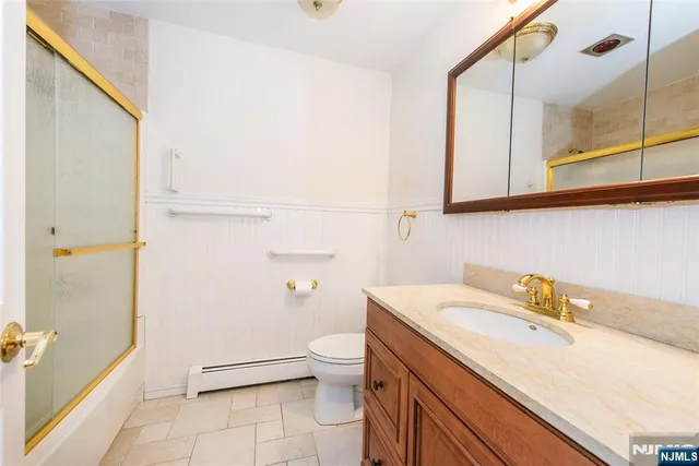 a bathroom with a granite countertop sink a toilet and shower