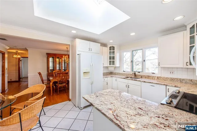 a large kitchen with kitchen island a dining table chairs and refrigerator