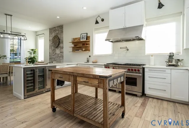 a kitchen with stainless steel appliances a stove a sink dishwasher and cabinets with wooden floor