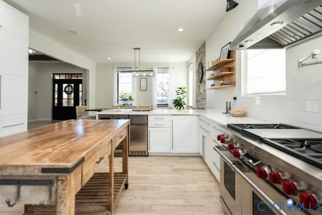 a kitchen with a stove a sink a window and dining table