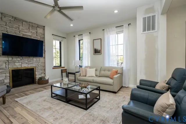 a living room with furniture a flat screen tv and a fireplace