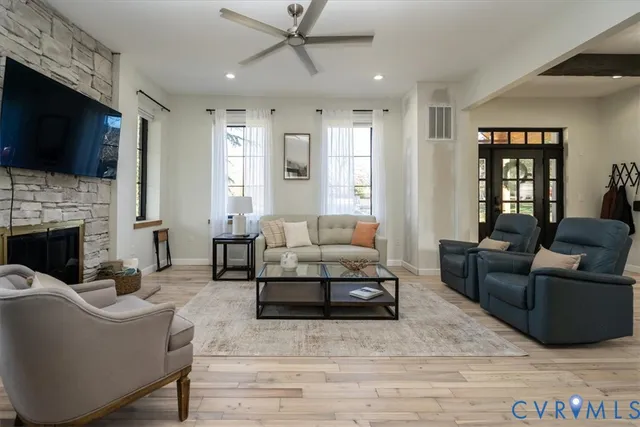a living room with furniture a flat screen tv and a fireplace