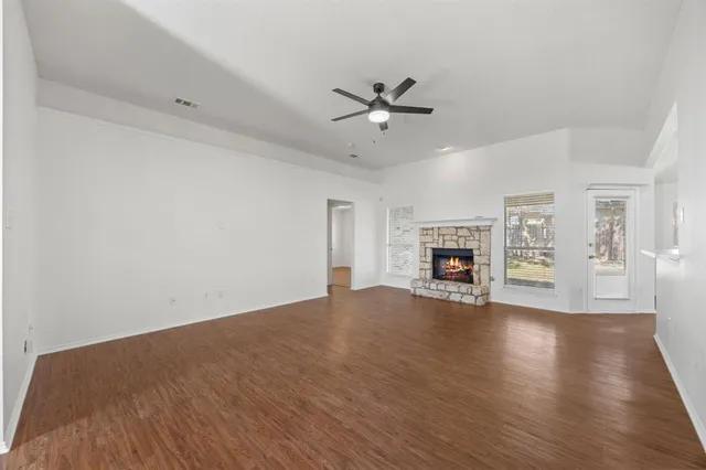 a view of empty room with wooden floor and fireplace