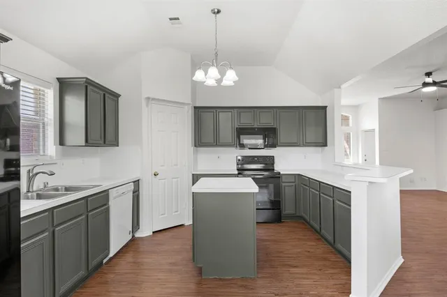 a kitchen with cabinets a sink stainless steel appliances and window