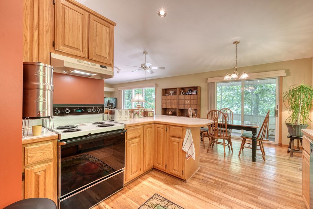 171 Mountain Top Road Blairsville, GA 30512 - Photo 21 of 54 a kitchen with a stove top oven cabinets dining table and a large window