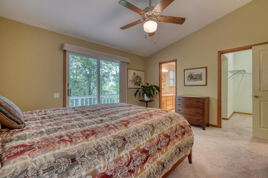 171 Mountain Top Road Blairsville, GA 30512 - Photo 27 of 54 a bedroom with a large bed and a chandelier