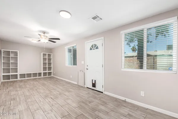 a view of an empty room with a window and wooden floor