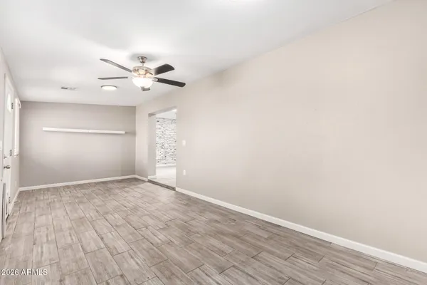 a view of an empty room with wooden floor