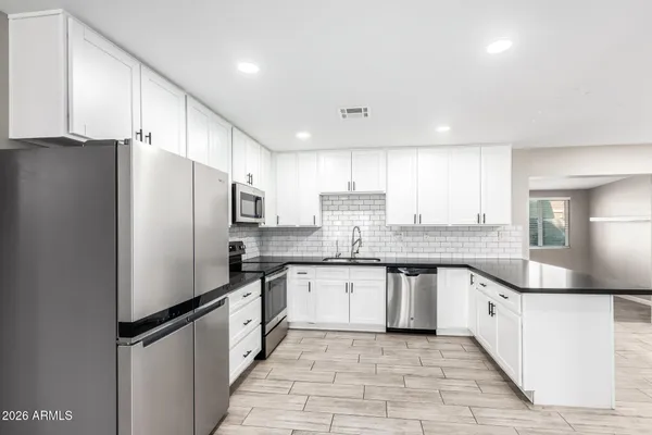 a kitchen with granite countertop a refrigerator and a sink