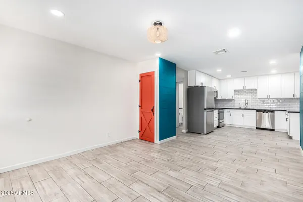 a view of kitchen with stainless steel appliances granite countertop a refrigerator and a sink