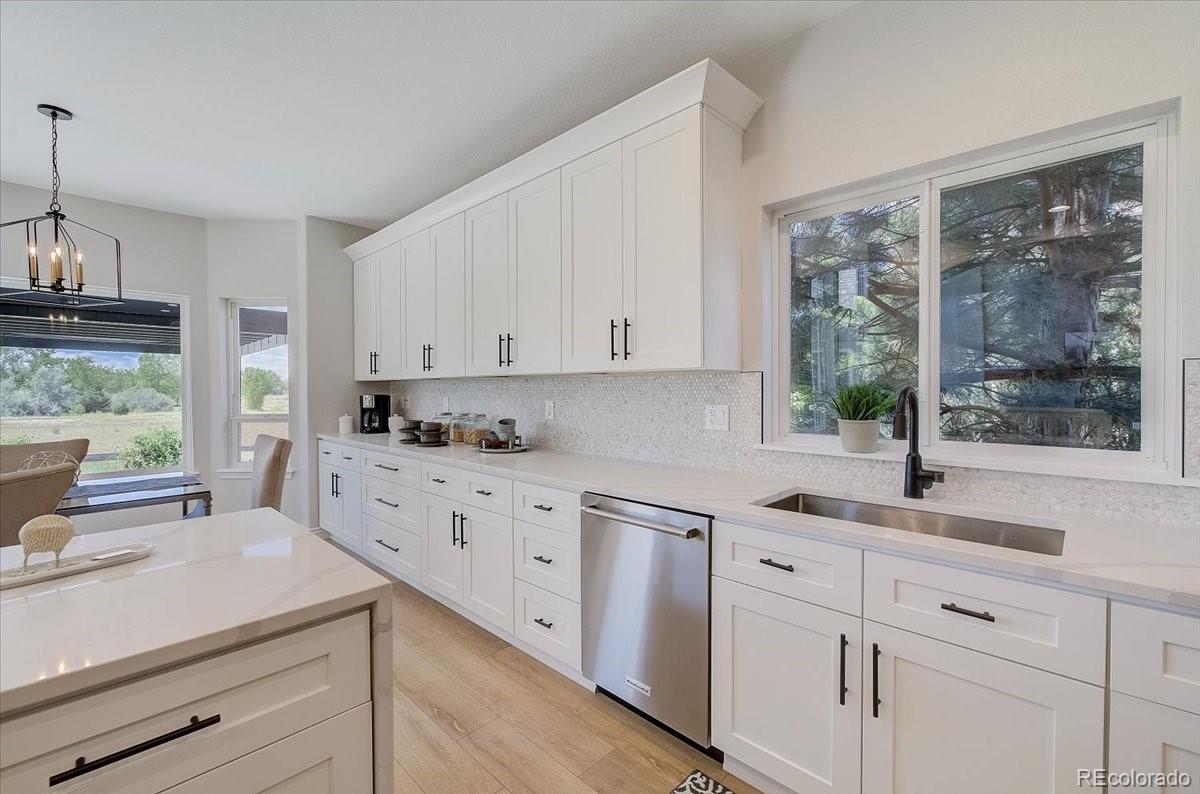 6063 South Eagle Street Centennial, CO 80016 - Photo 13 of 40 a kitchen with white cabinets and window