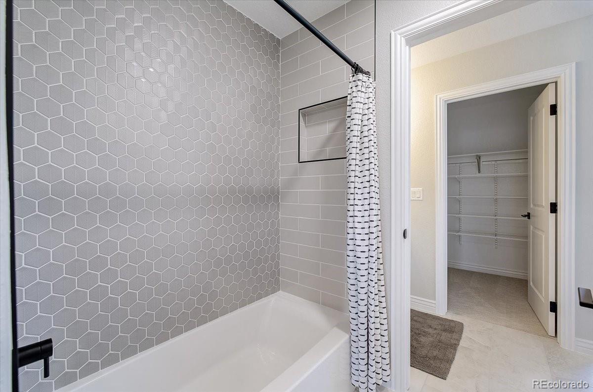 6063 South Eagle Street Centennial, CO 80016 - Photo 18 of 40 a bathroom with a bathtub and shower
