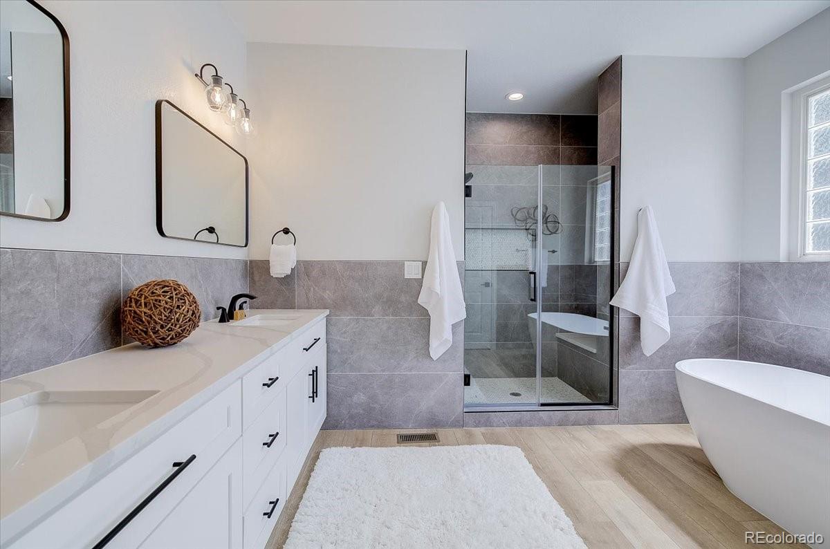 6063 South Eagle Street Centennial, CO 80016 - Photo 25 of 40 a spacious bathroom with a tub sink and mirror