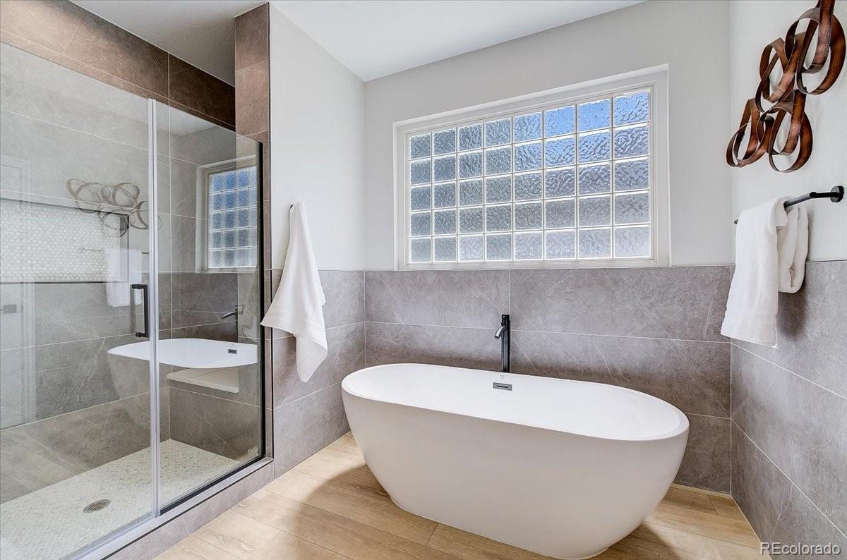 6063 South Eagle Street Centennial, CO 80016 - Photo 26 of 40 a bathroom with a bathtub and a shower