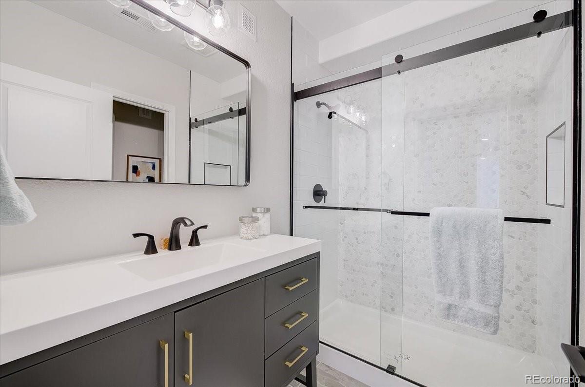 6063 South Eagle Street Centennial, CO 80016 - Photo 30 of 40 a bathroom with a sink and mirror