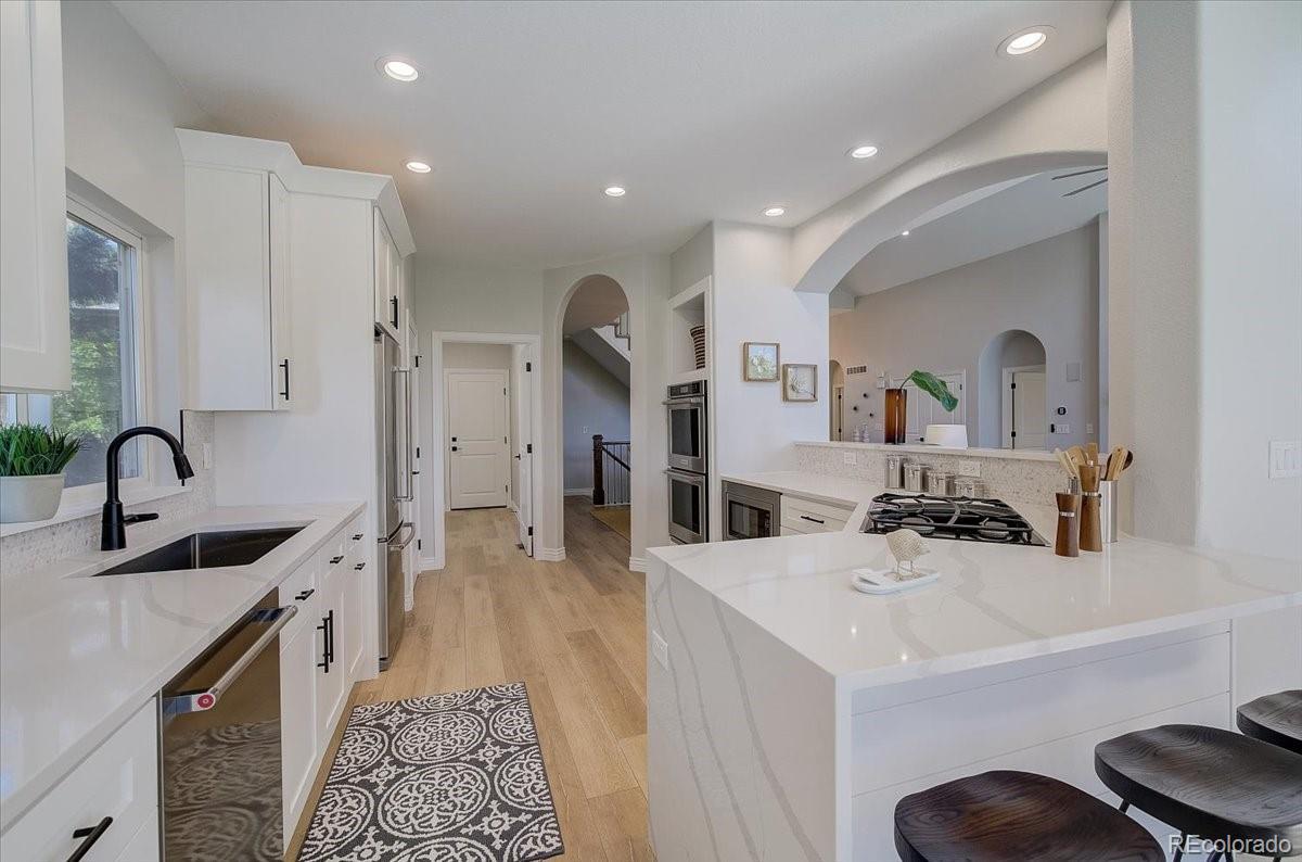 6063 South Eagle Street Centennial, CO 80016 - Photo 10 of 40 a kitchen with stainless steel appliances a sink a stove a refrigerator and cabinets