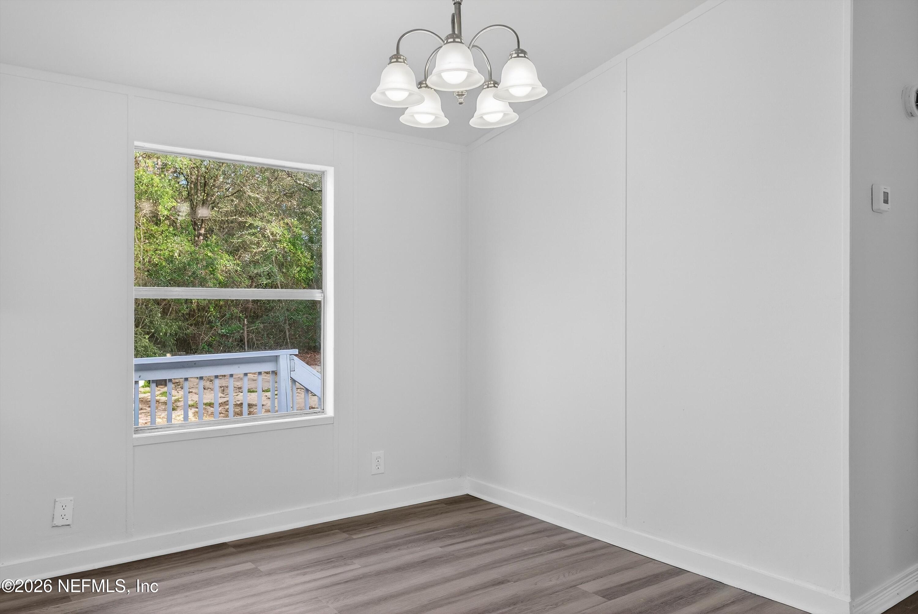 7595 Oak Forest Road Keystone Heights, FL 32656 - Photo 14 of 49 a view of a room with wooden floor and chandelier