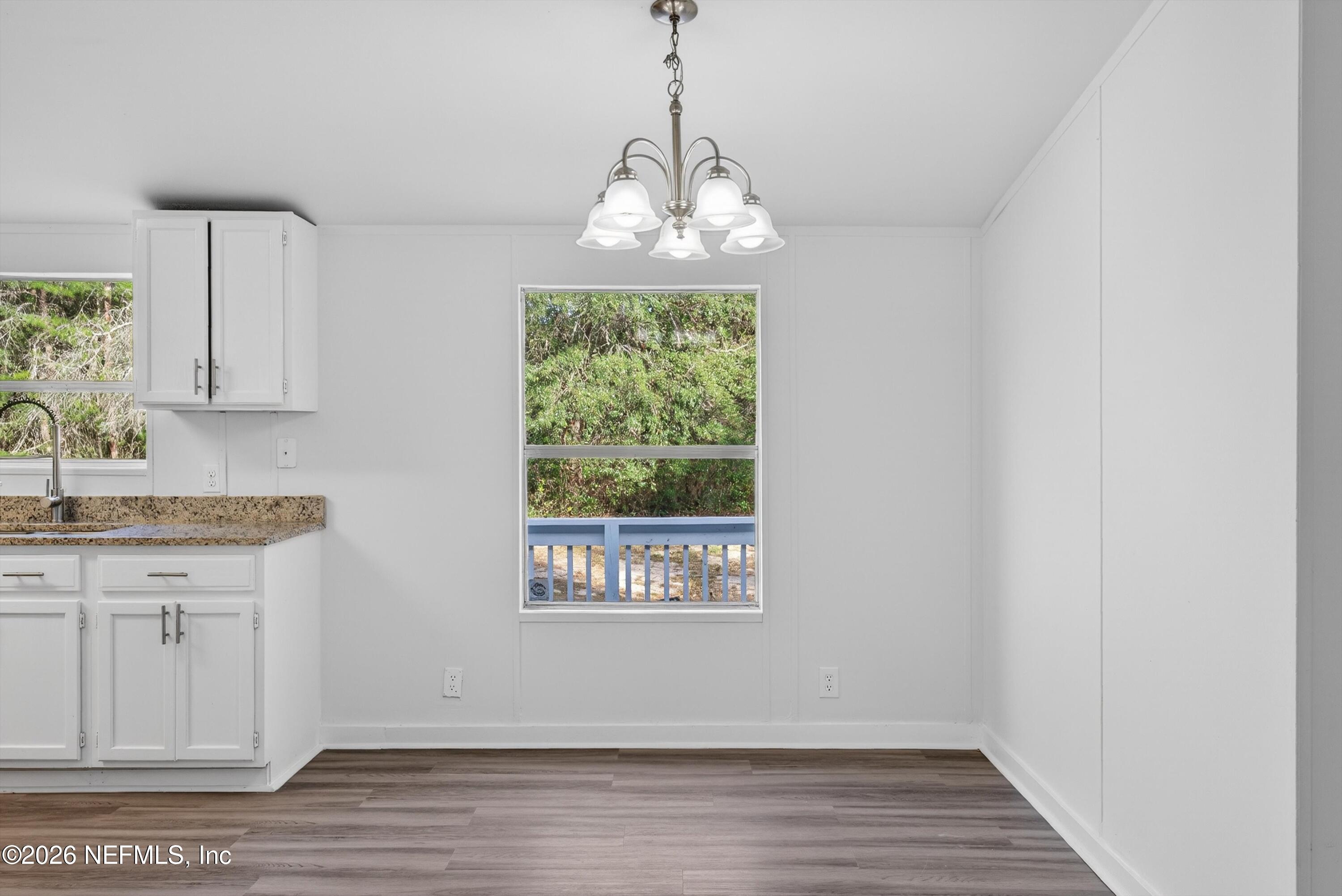 7595 Oak Forest Road Keystone Heights, FL 32656 - Photo 15 of 49 an empty room with wooden floor and windows