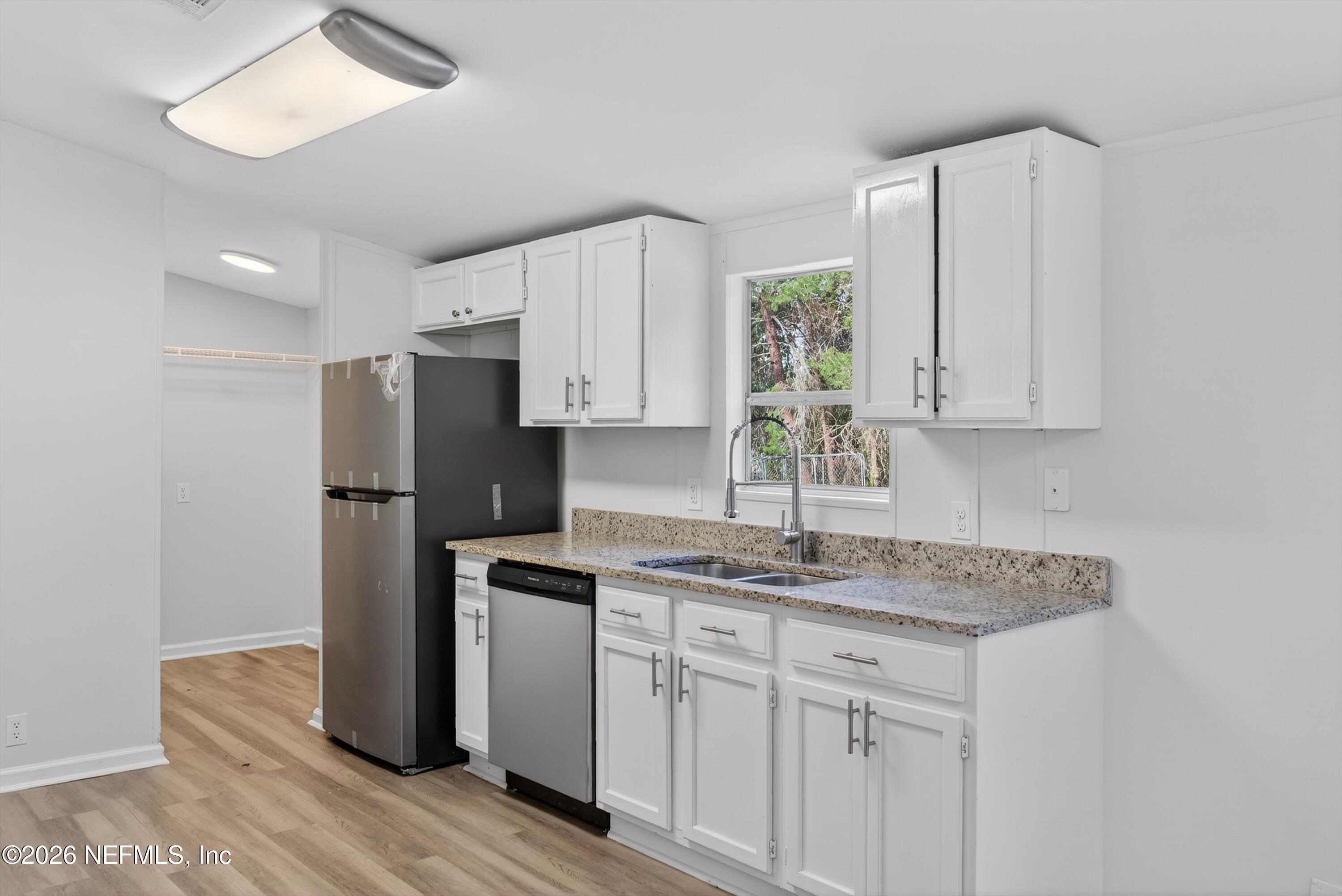 7595 Oak Forest Road Keystone Heights, FL 32656 - Photo 17 of 49 a kitchen with stainless steel appliances granite countertop white cabinets and a refrigerator