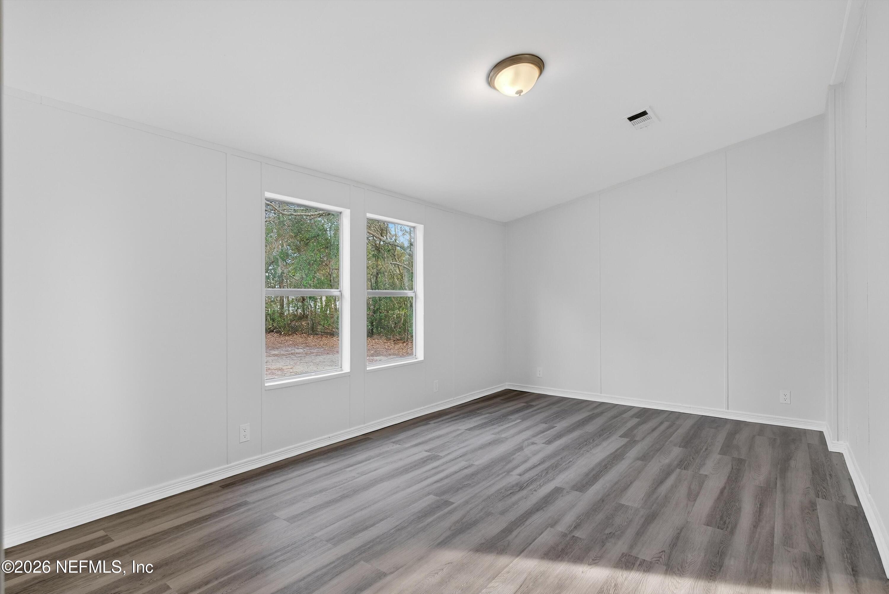 7595 Oak Forest Road Keystone Heights, FL 32656 - Photo 21 of 49 an empty room with wooden floor and windows