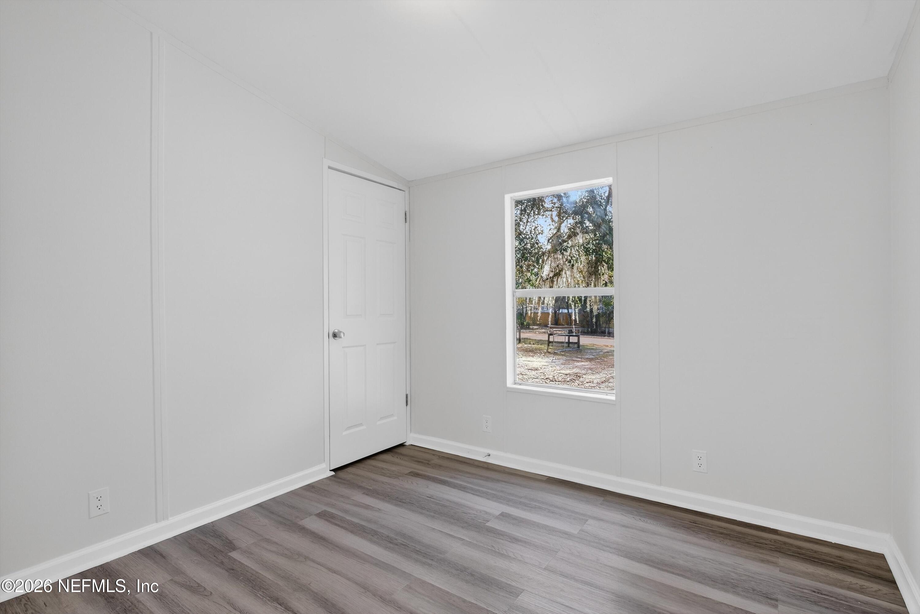 7595 Oak Forest Road Keystone Heights, FL 32656 - Photo 30 of 49 a view of an empty room with wooden floor and a window