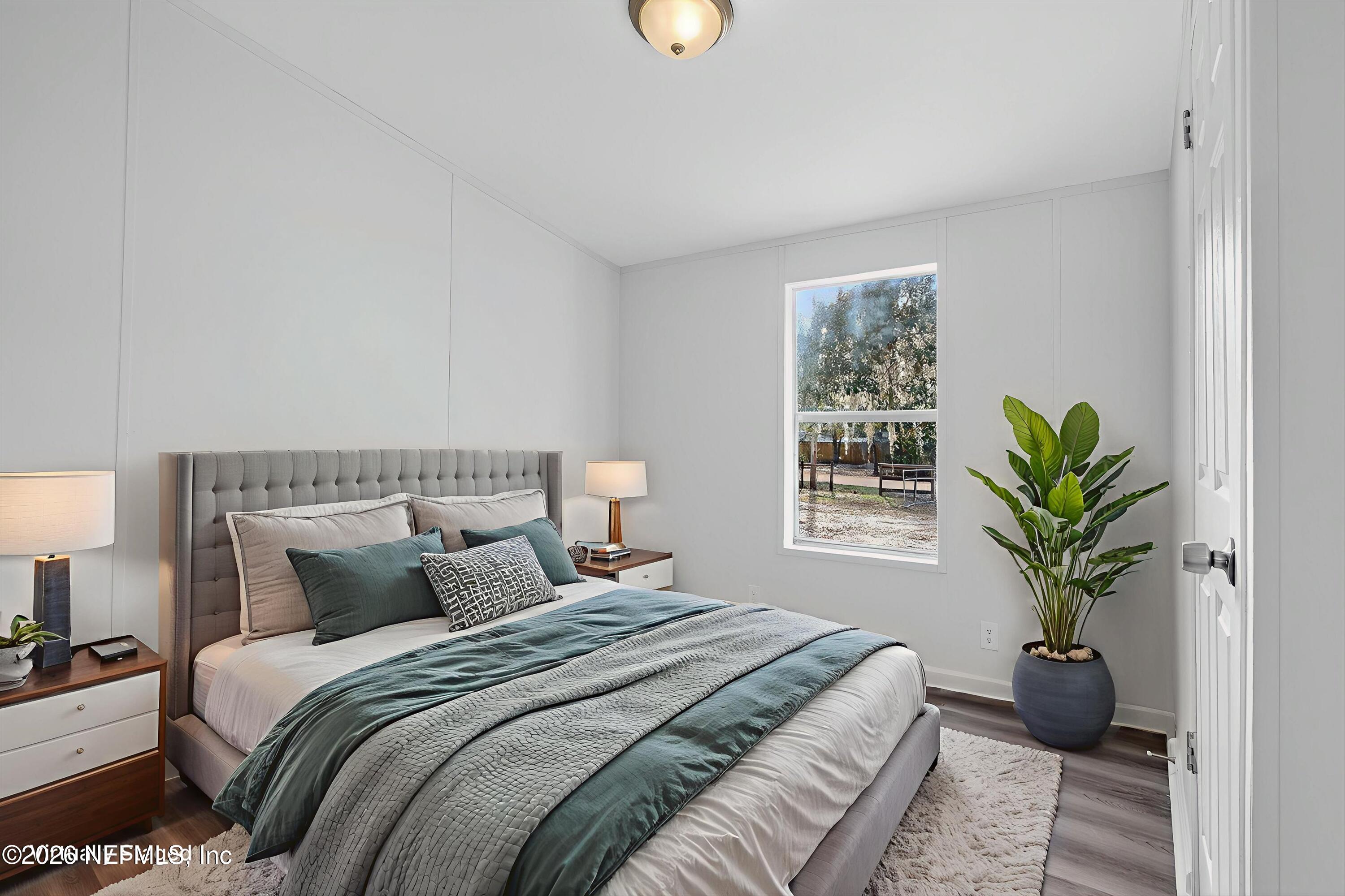 7595 Oak Forest Road Keystone Heights, FL 32656 - Photo 33 of 49 a bedroom with a large bed and a potted plant
