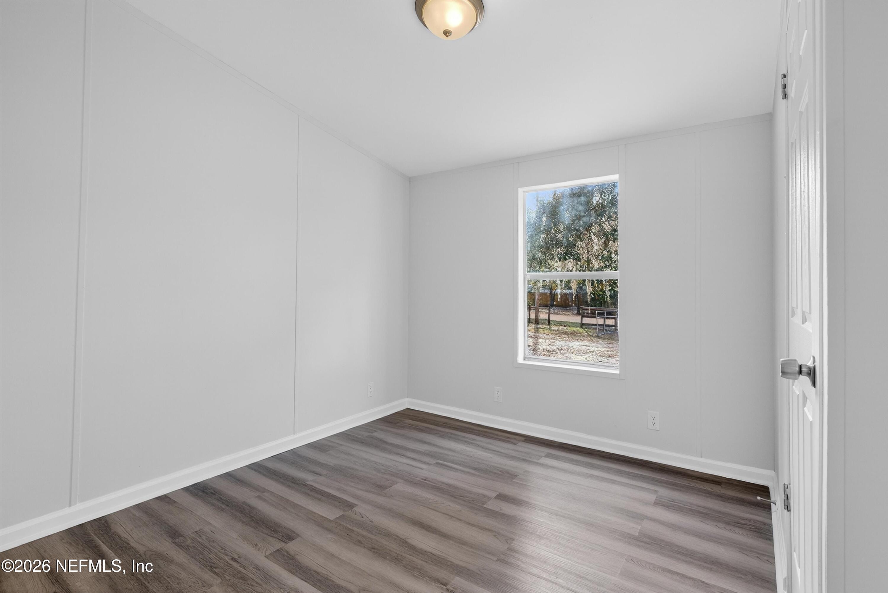 7595 Oak Forest Road Keystone Heights, FL 32656 - Photo 34 of 49 a view of an empty room with wooden floor and a window