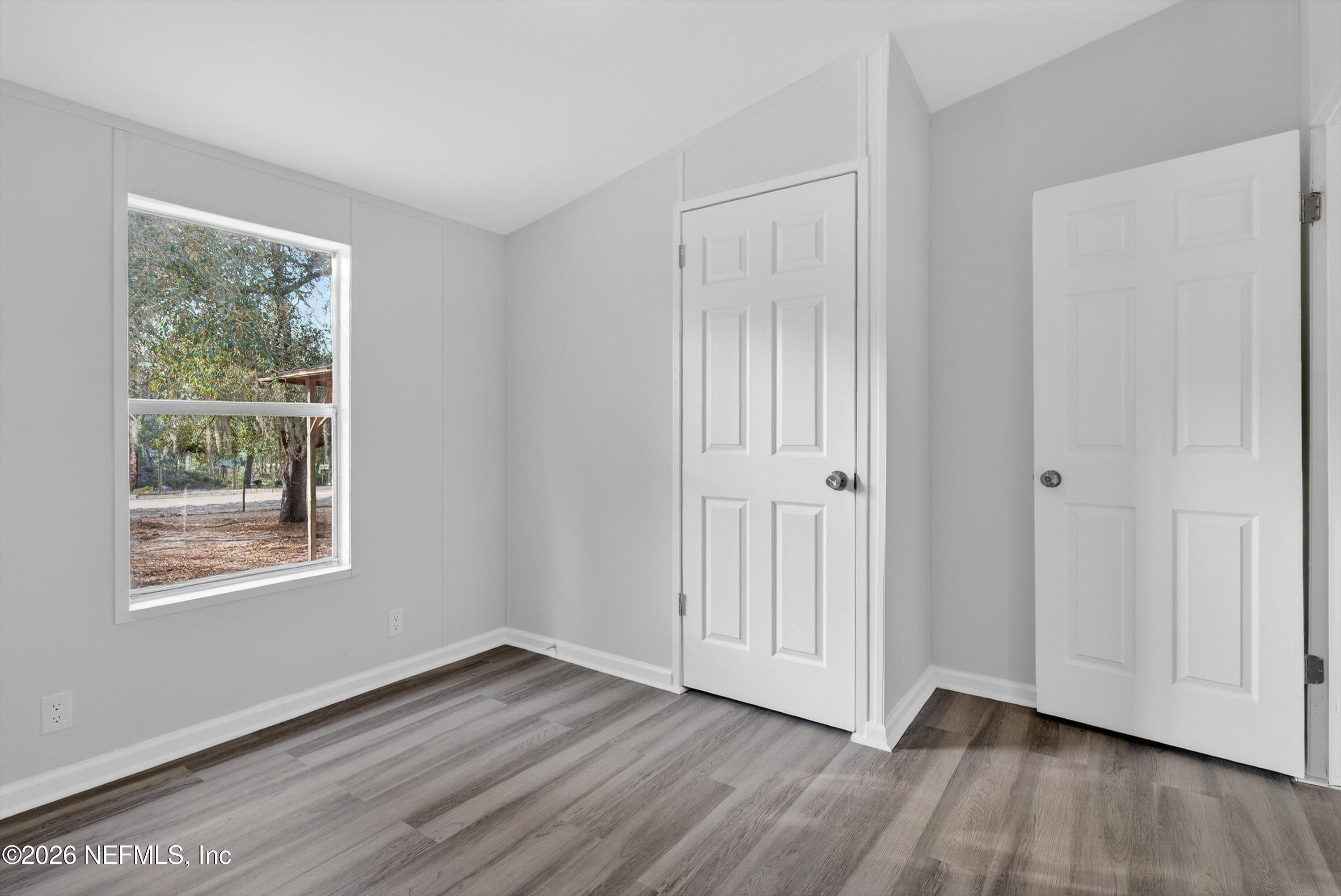 7595 Oak Forest Road Keystone Heights, FL 32656 - Photo 35 of 49 a view of an empty room with wooden floor and a window