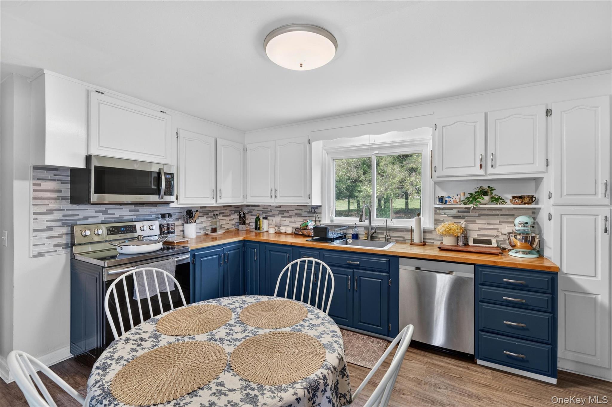 151 Laroe Road Chester, NY 10918 - Photo 17 of 43 a kitchen with stainless steel appliances granite countertop a stove top oven a sink dishwasher and white cabinets with wooden floor