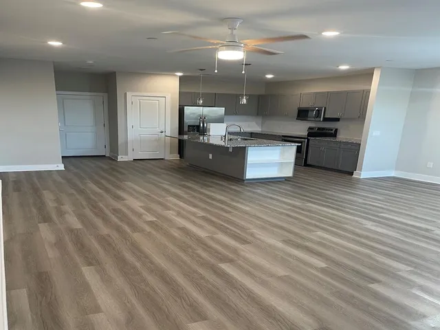 a large kitchen with kitchen island a sink stainless steel appliances and cabinets