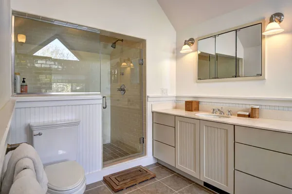 a bathroom with a toilet a sink and mirror