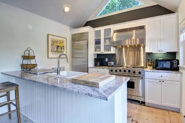 a kitchen with granite countertop a sink stove and cabinets