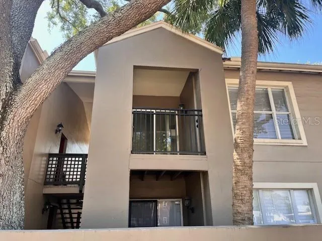 a view of backyard of a house with plants and wooden fence