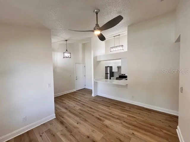 a view of a room with wooden floor and a ceiling fan