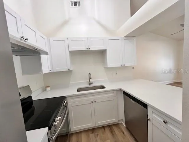 a kitchen with a sink dishwasher and cabinets