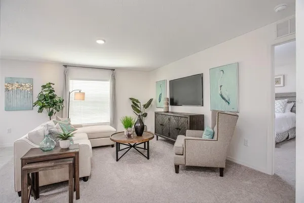 a living room with furniture kitchen view and a potted plant