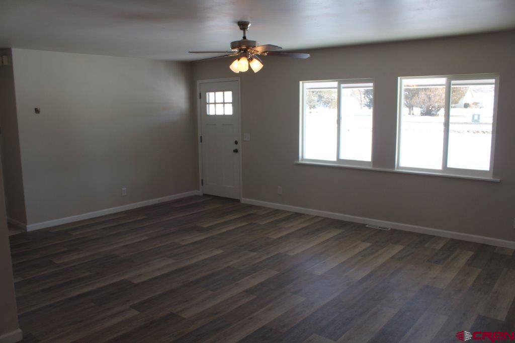 1191 Pioneer Road Delta, CO 81416 - Photo 4 of 22 an empty room with wooden floor and windows