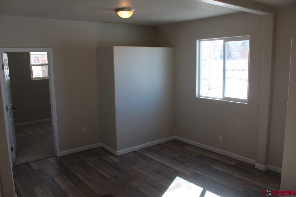 1191 Pioneer Road Delta, CO 81416 - Photo 8 of 22 an empty room with wooden floor and windows