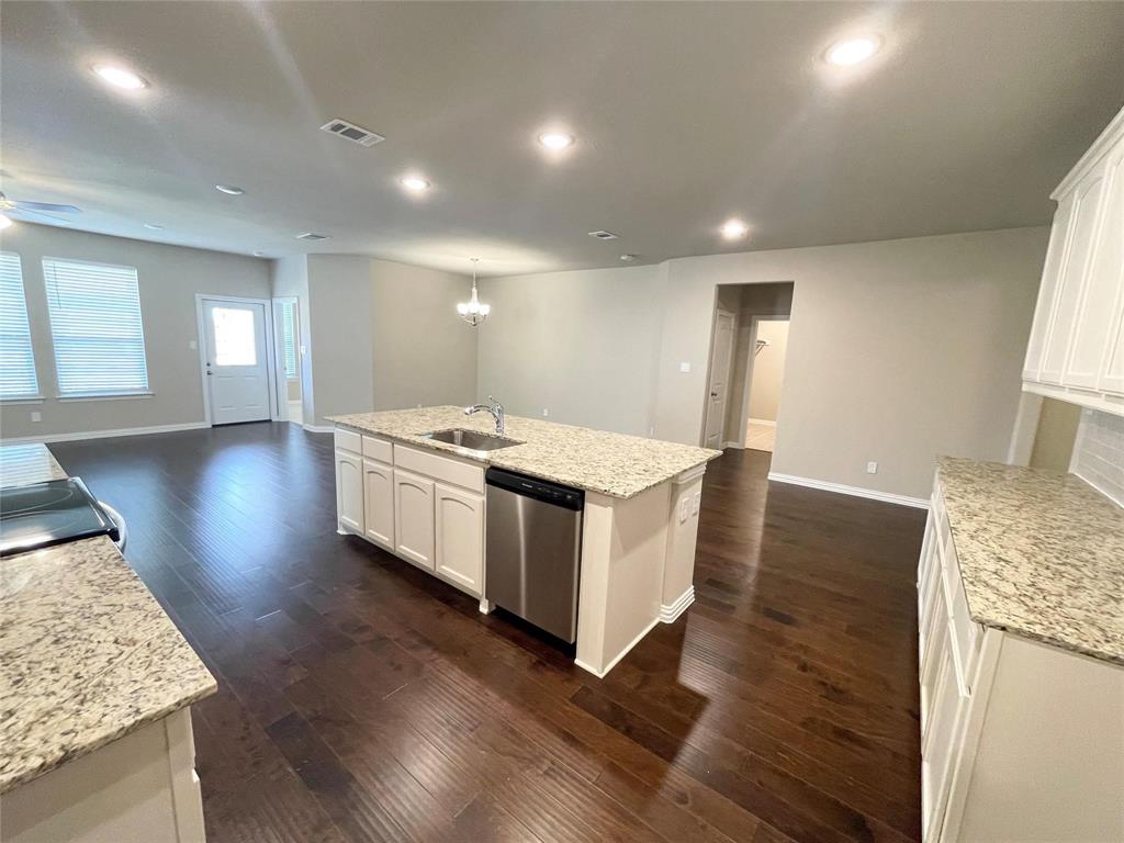 832 Porcupine Drive Springtown, TX 76082 - Photo 11 of 16 a large white kitchen with wooden floors and stainless steel appliances