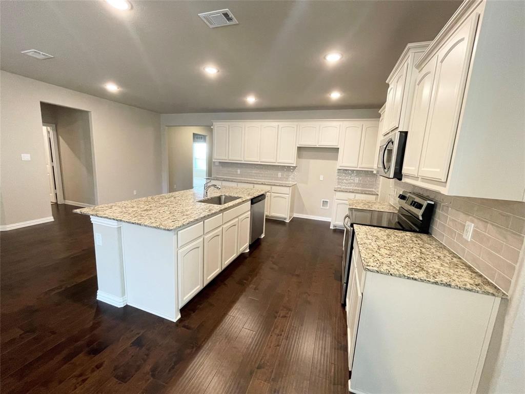 832 Porcupine Drive Springtown, TX 76082 - Photo 6 of 16 a large kitchen with kitchen island a large counter top space a sink stainless steel appliances and cabinets