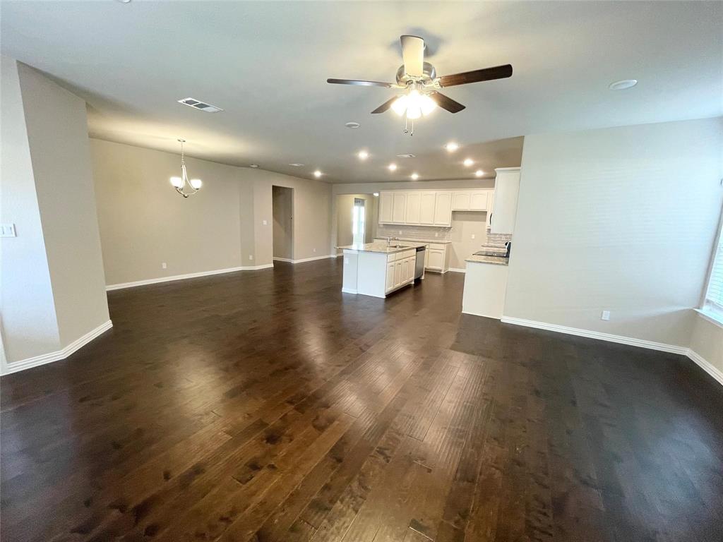 832 Porcupine Drive Springtown, TX 76082 - Photo 7 of 16 a view of an empty room and kitchen with wooden floor
